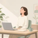 책상 앞에 앉아 잠시 눈을 감고 천천히 숨을 고르는 사람의 모습