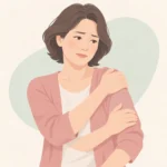한쪽 어깨를 반대 손으로 감싸 쥐고 팔뚝 위쪽을 문지르는 중년 여성의 상반신