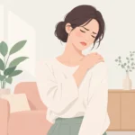 한쪽 어깨를 손으로 감싸 쥐고 불편한 표정을 짓는 사람